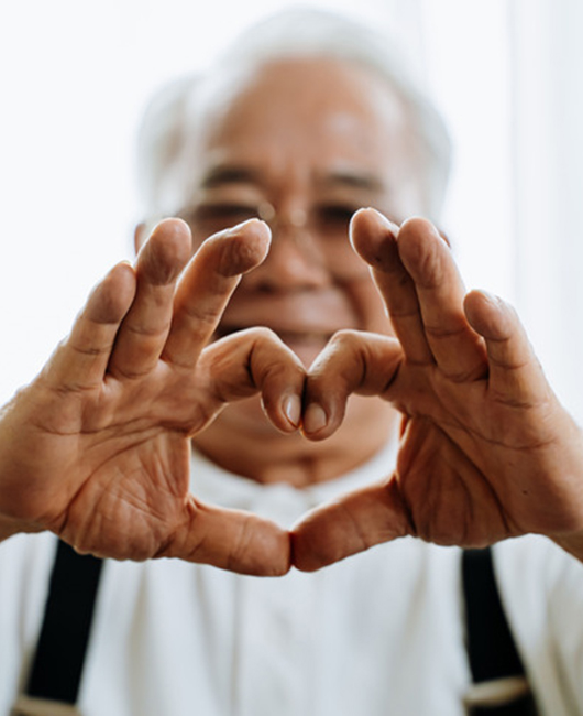 senior man making a heart symbol with his hands